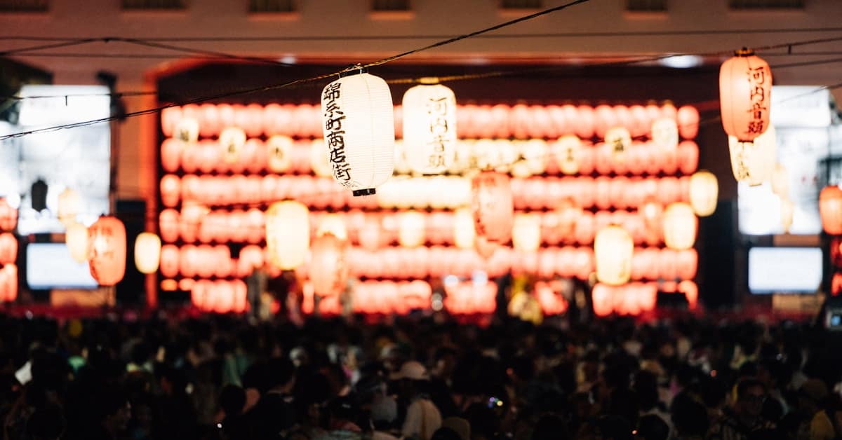 dragon boat festival - illuminated paper lanterns over evening crowd celebration