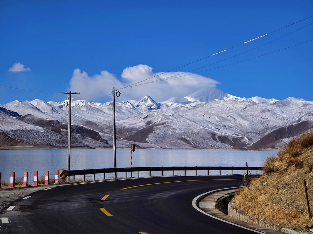 Turquoise alpine lake on the Tibetan plateau in western Sichuan with snow-capped peaks China