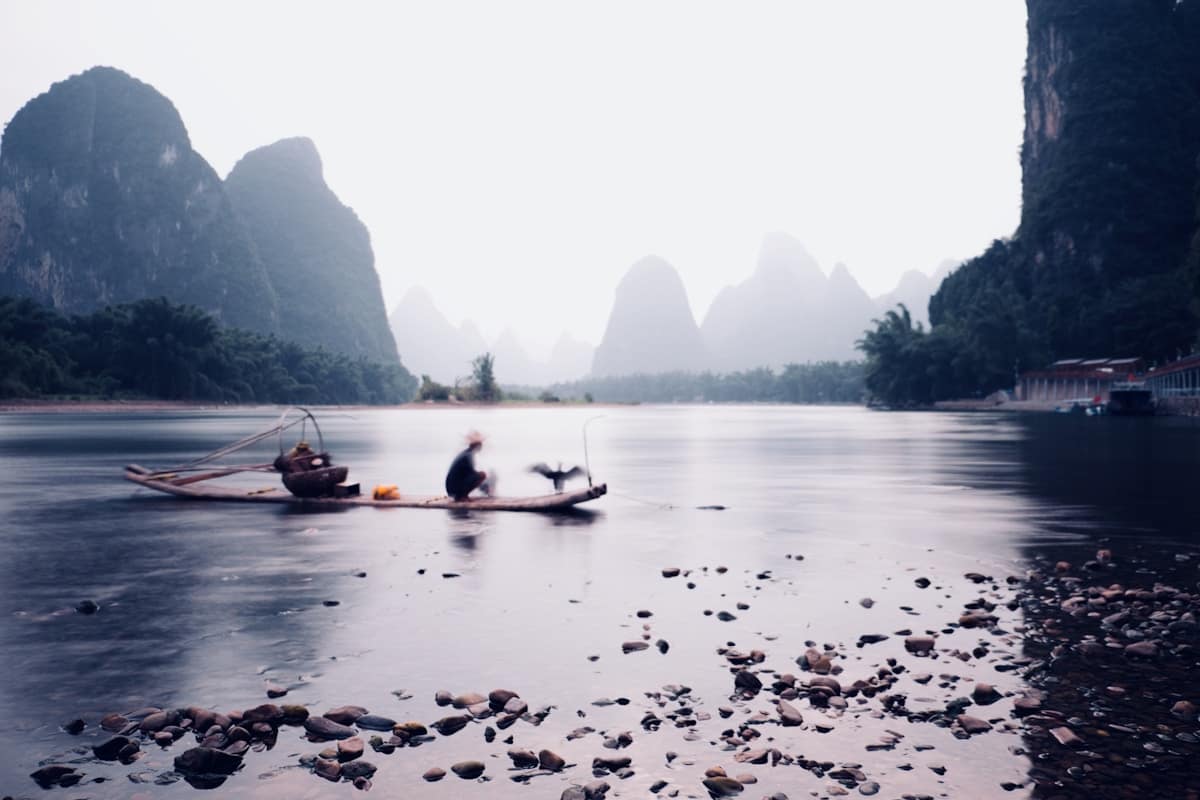 Traditional Chinese fisherman on bamboo raft with cormorant birds on Li River Guilin
