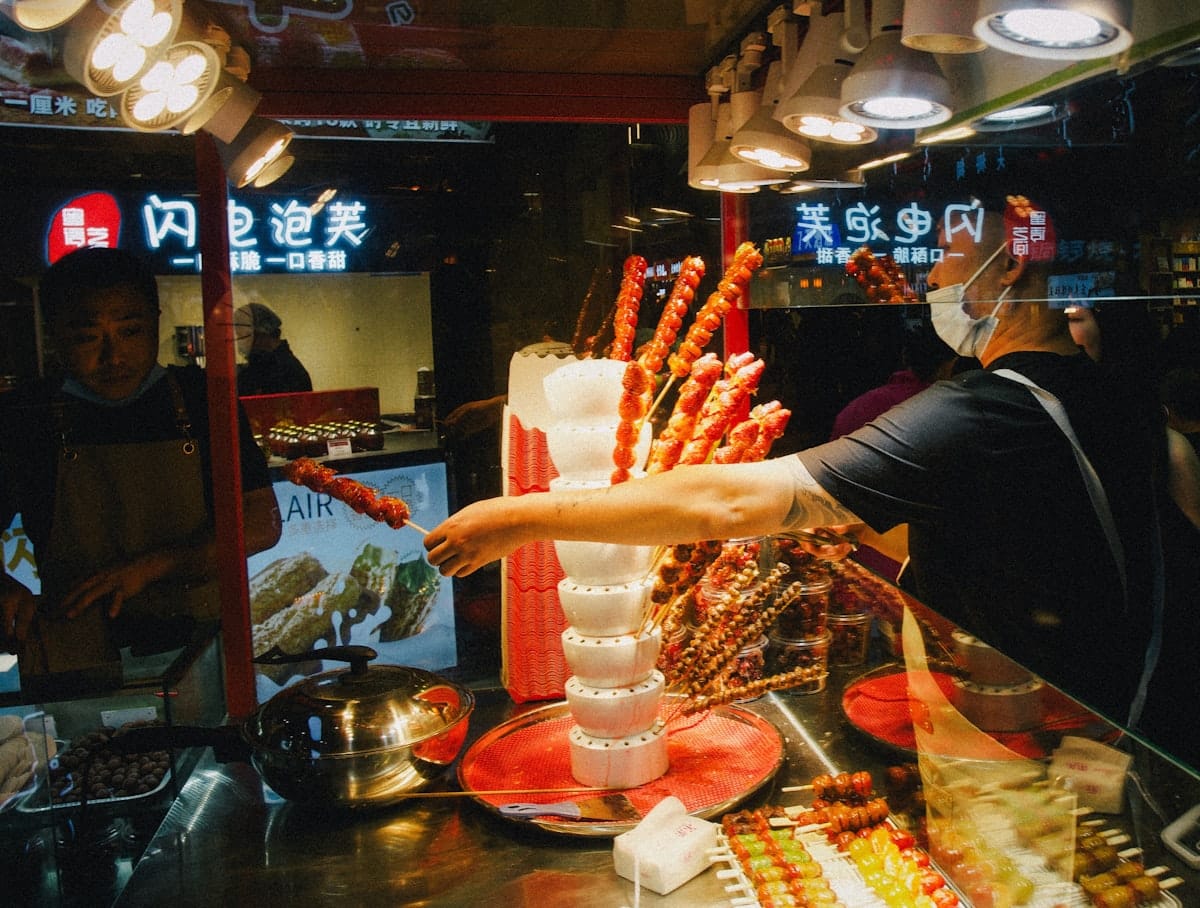 a week in beijing - small Chinese street food stall at night with cooked dishes on display
