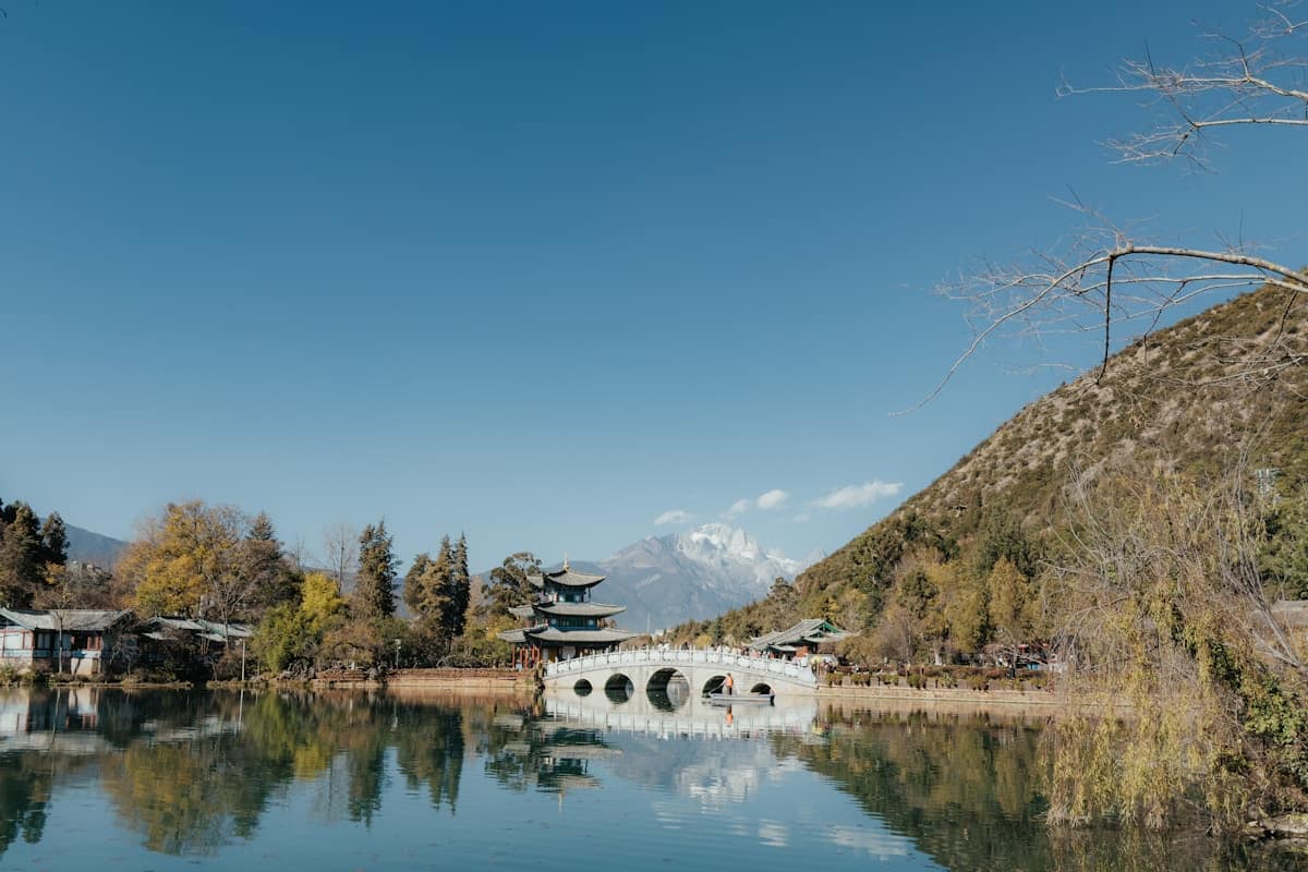 china summer travel - stone bridge over a calm Yunnan highland lake with mountains