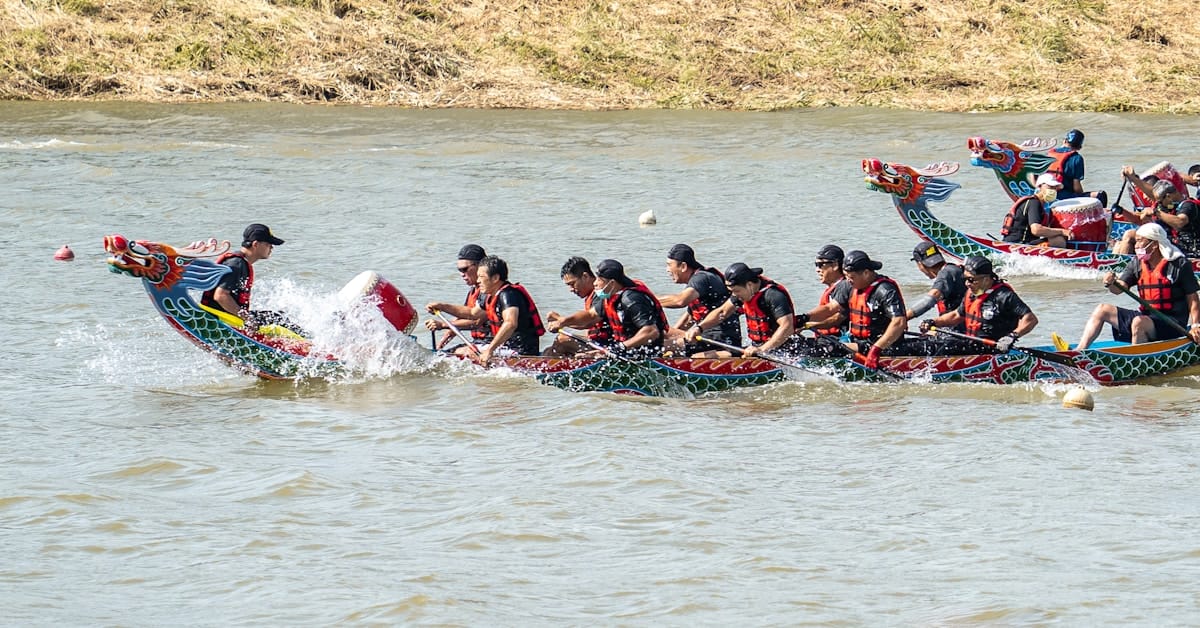 dragon boat racing - team paddling in formation on the river