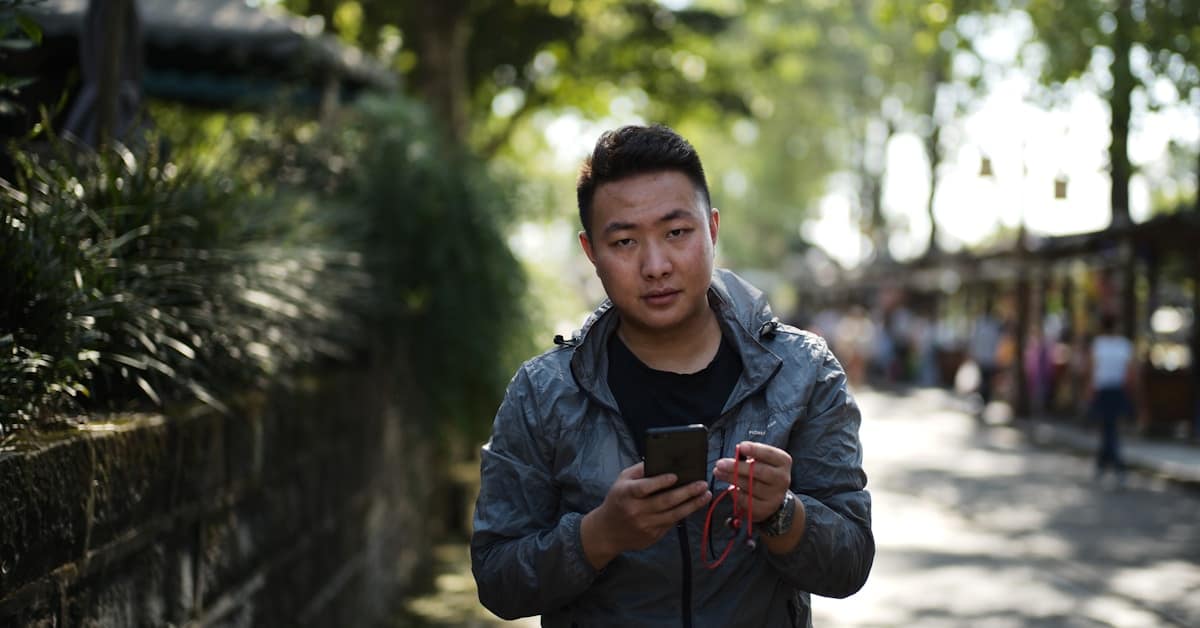 china navigation apps - man using smartphone outdoors navigation