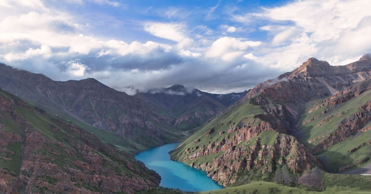 jiuzhaigou travel - winding blue river through green mountain valley