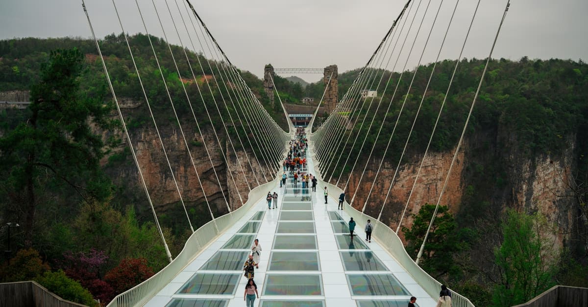 Zhangjiajie glass bridge - visitors walking across transparent walkway
