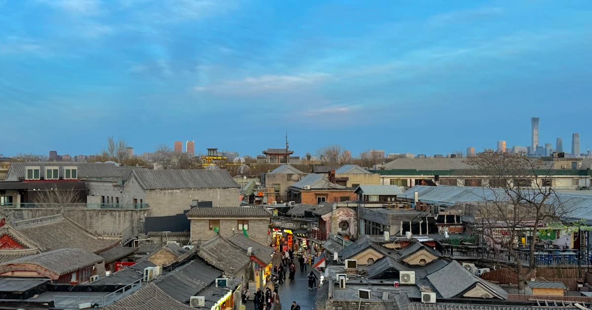 beijing hutong - traditional grey-brick buildings line a narrow hutong alleyway at dusk