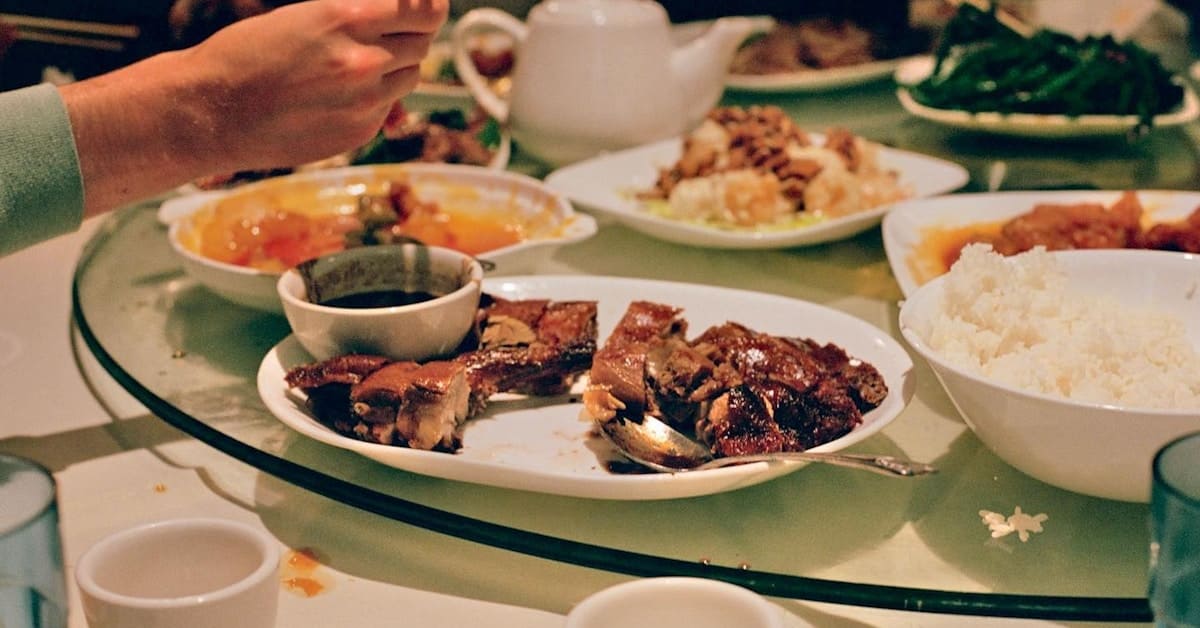 china etiquette - group of people sitting around a table with food