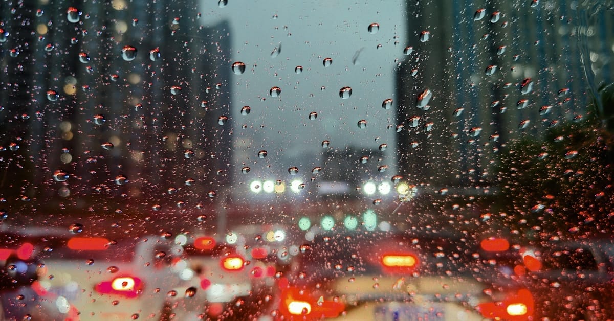 china in july - city street viewed through rain-covered window during typhoon season