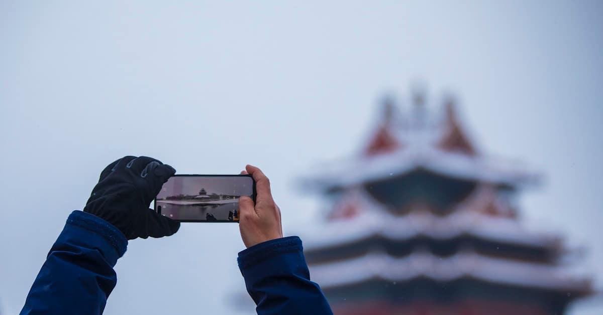 china travel apps - person holding smartphone with app interface
