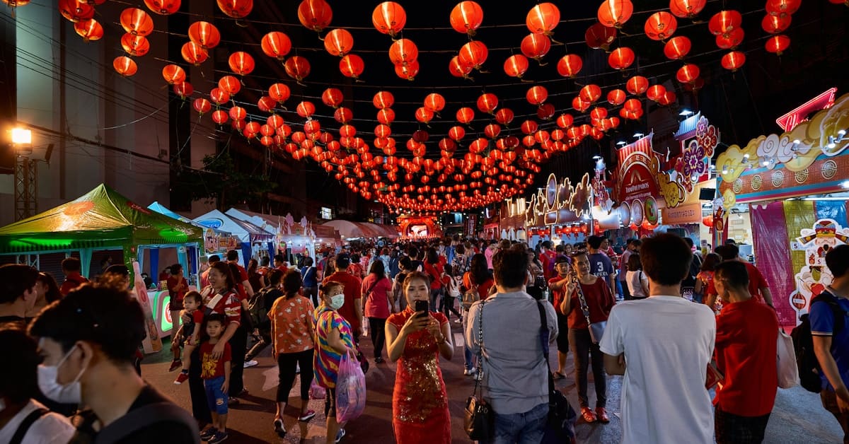 dragon boat festival - crowds celebrating under red lanterns in a Chinese street