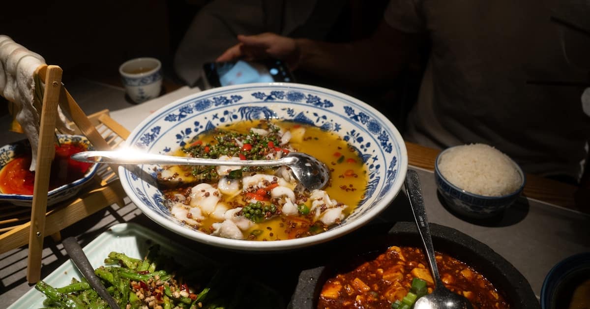 sichuan hotpot - table full of Chinese dishes and spicy Sichuan cuisine